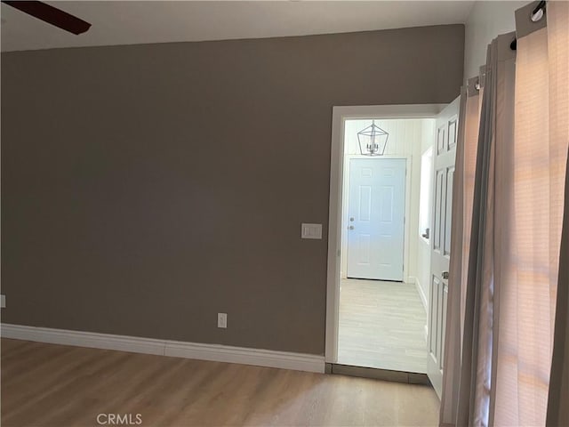 entryway with ceiling fan with notable chandelier and light wood-type flooring