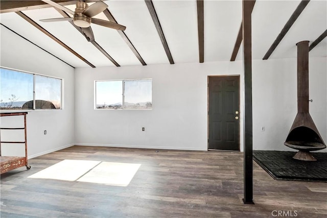 interior space featuring hardwood / wood-style floors, vaulted ceiling with beams, a wood stove, and ceiling fan