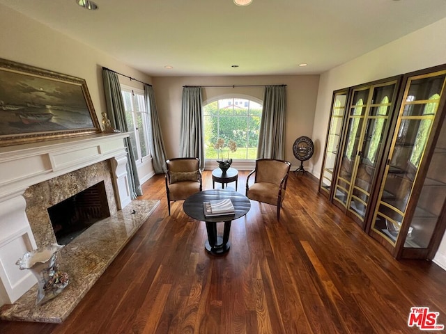 sitting room featuring a premium fireplace and dark wood-type flooring