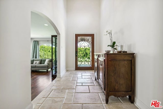 foyer entrance with a high ceiling and light hardwood / wood-style floors