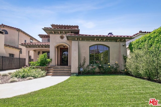 mediterranean / spanish house featuring a front yard