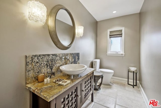 bathroom with tasteful backsplash, vanity, and toilet