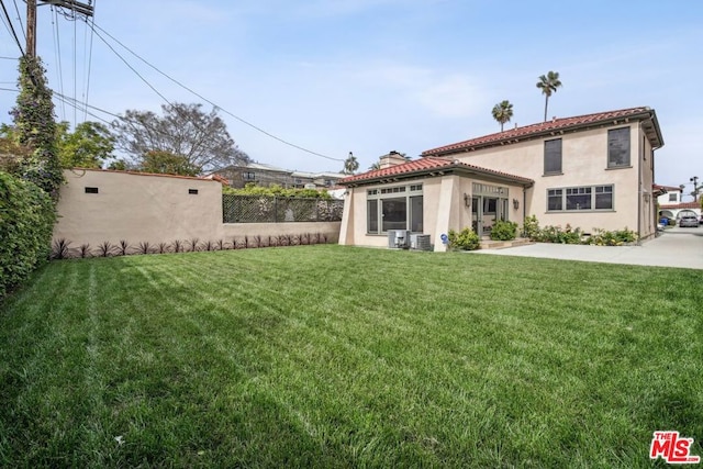 rear view of property with a lawn and central AC unit