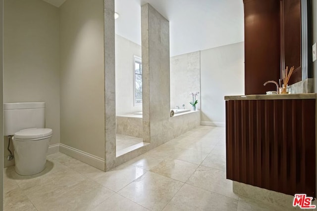 bathroom featuring tile patterned flooring, a bath, vanity, and toilet