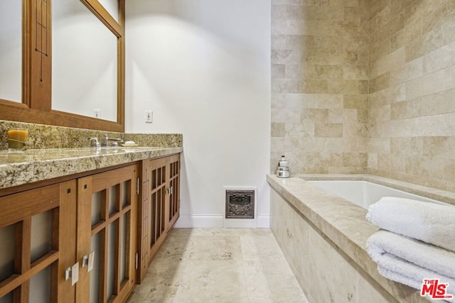 bathroom with vanity and a relaxing tiled tub