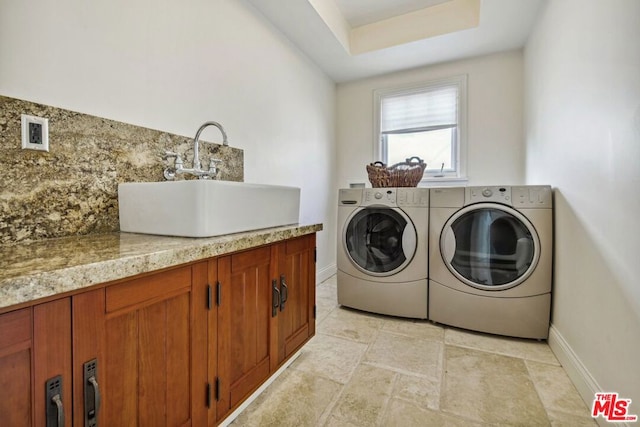 washroom featuring washer and clothes dryer, cabinets, and sink