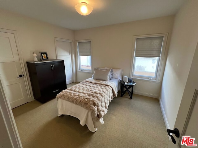 carpeted bedroom featuring multiple windows