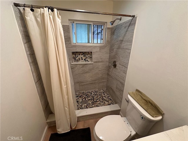 bathroom featuring toilet and a stall shower