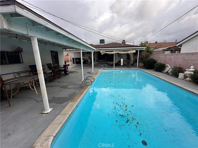 view of swimming pool with a patio area, fence, and a fenced in pool