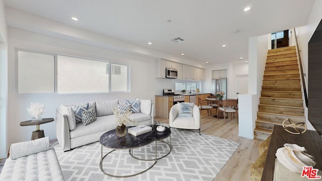 living room featuring light hardwood / wood-style floors and sink