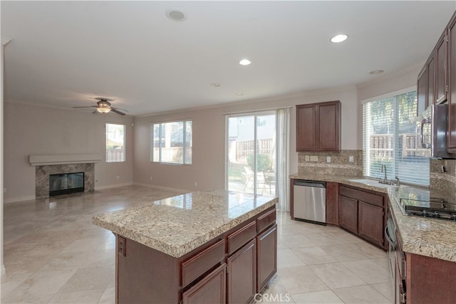 kitchen featuring a kitchen island, decorative backsplash, stainless steel appliances, a premium fireplace, and ornamental molding