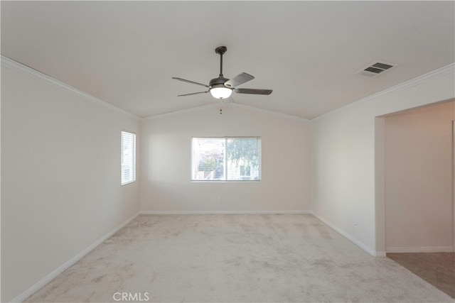 empty room featuring crown molding, light colored carpet, vaulted ceiling, and ceiling fan