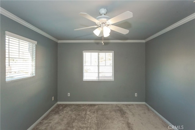 carpeted empty room with ornamental molding, ceiling fan, and a wealth of natural light