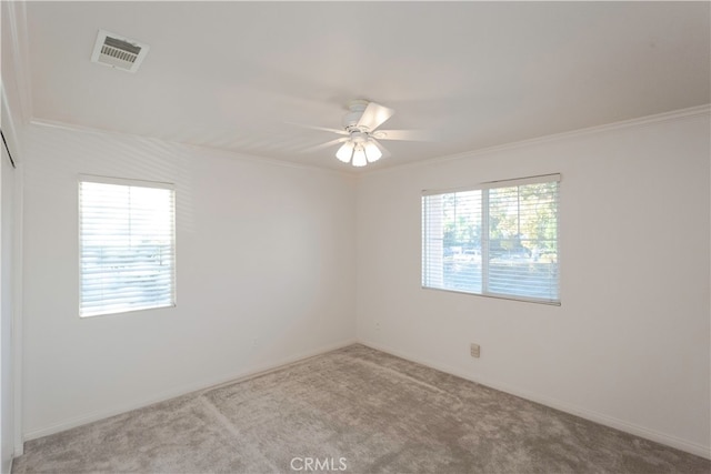 spare room featuring ornamental molding, light colored carpet, and a healthy amount of sunlight