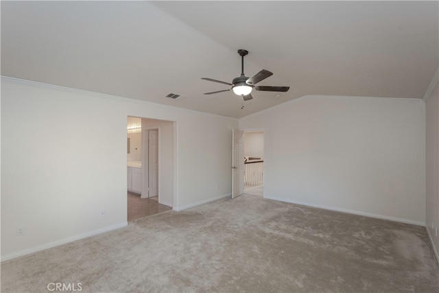 unfurnished bedroom featuring lofted ceiling, light colored carpet, connected bathroom, and ceiling fan