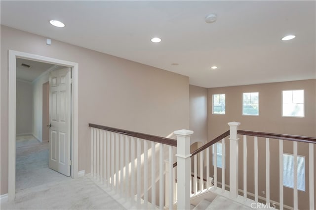 hall featuring crown molding and light colored carpet