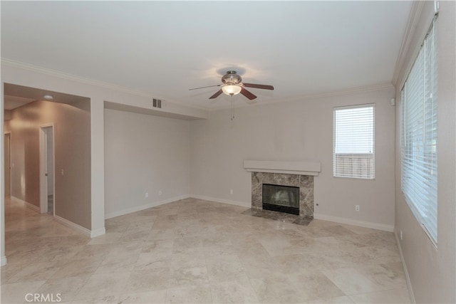 unfurnished living room with ornamental molding, a high end fireplace, and ceiling fan