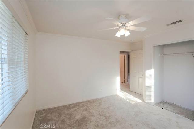 unfurnished bedroom featuring a closet, ceiling fan, ornamental molding, and light colored carpet