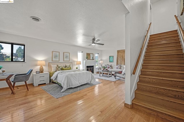 bedroom featuring ceiling fan, a textured ceiling, and light hardwood / wood-style flooring