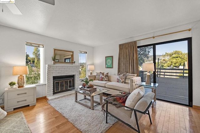 living room with light wood-type flooring and a brick fireplace