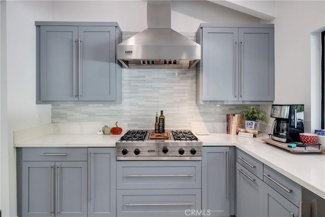 kitchen with tasteful backsplash, stainless steel gas cooktop, gray cabinets, and wall chimney exhaust hood