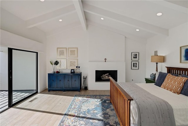 bedroom with lofted ceiling with beams, access to exterior, and light hardwood / wood-style flooring