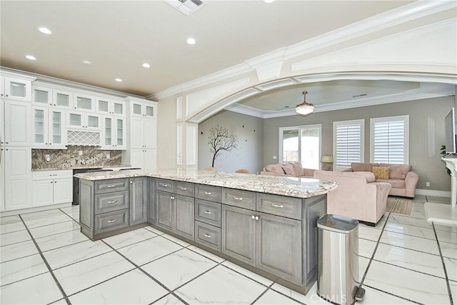 kitchen featuring a kitchen island, tasteful backsplash, white cabinetry, and ornamental molding