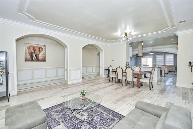 living room with light wood-type flooring and ornamental molding