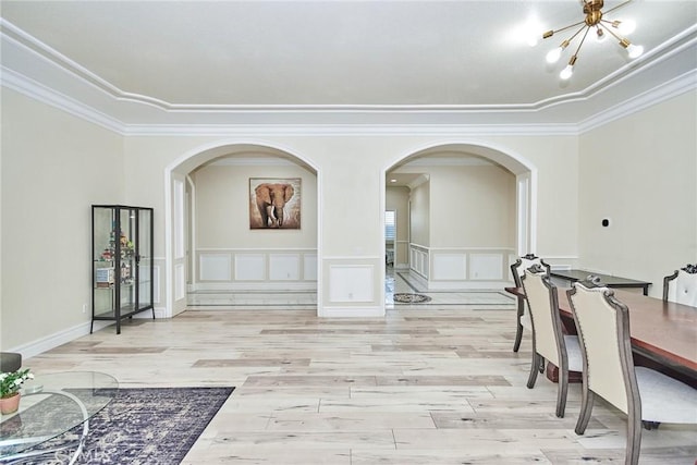 interior space featuring light hardwood / wood-style floors, crown molding, and a notable chandelier