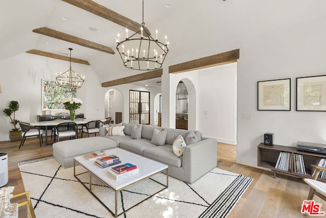 living room with beam ceiling, high vaulted ceiling, a notable chandelier, and light wood-type flooring