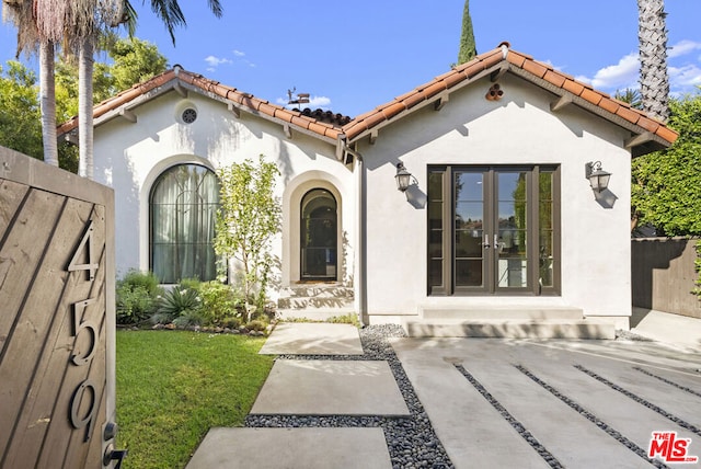 view of front of house with a front lawn and french doors