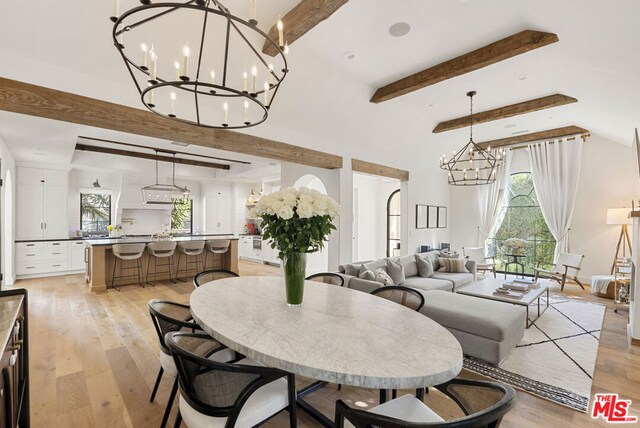 dining area featuring vaulted ceiling with beams and light hardwood / wood-style floors