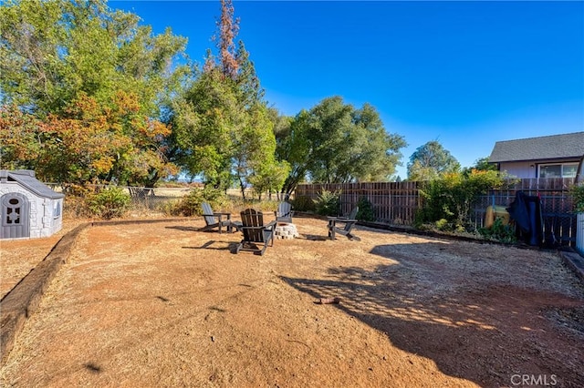 view of yard with a storage shed and a fire pit