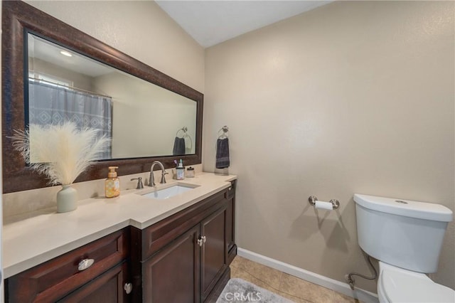 bathroom featuring toilet, vanity, and tile patterned flooring