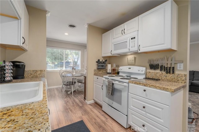 kitchen featuring white appliances, white cabinetry, sink, light stone counters, and crown molding