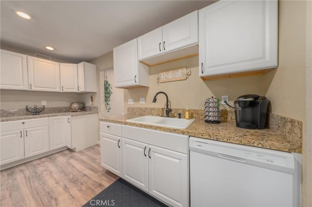 kitchen featuring white cabinetry, dishwasher, light hardwood / wood-style flooring, light stone counters, and sink