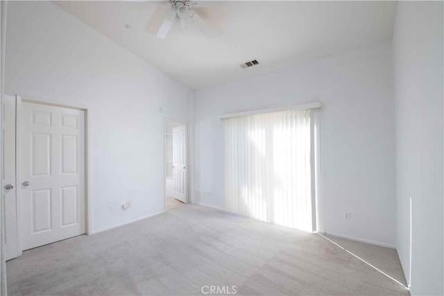 carpeted empty room featuring ceiling fan and vaulted ceiling