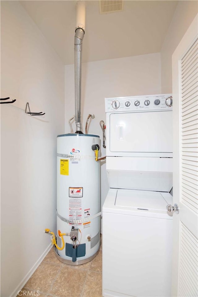 utilities with stacked washing maching and dryer and gas water heater