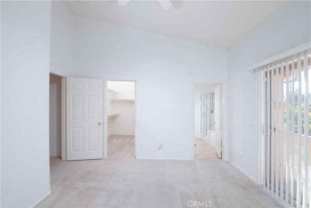 carpeted spare room with high vaulted ceiling