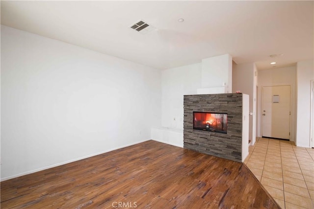 unfurnished living room featuring a fireplace and light wood-type flooring