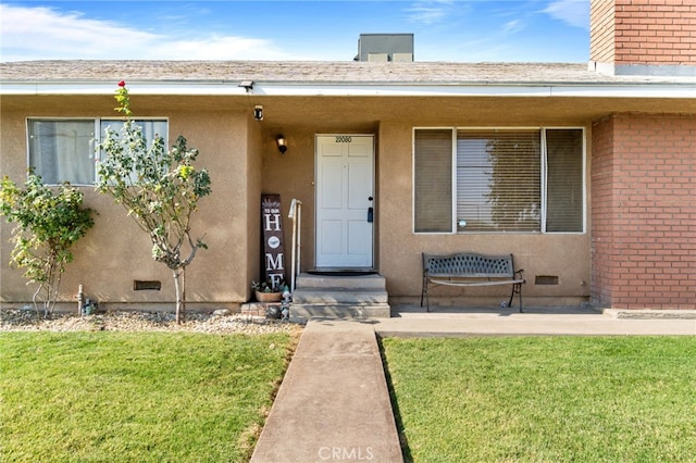 entrance to property featuring a lawn