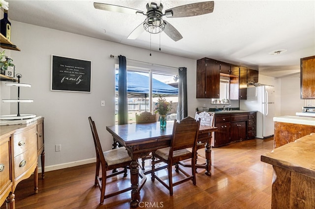 dining space with ceiling fan, hardwood / wood-style flooring, and sink