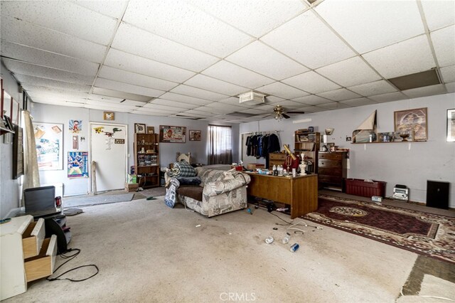 carpeted living room with a drop ceiling and ceiling fan