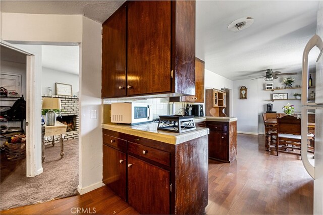 kitchen with ceiling fan, dark hardwood / wood-style flooring, and kitchen peninsula