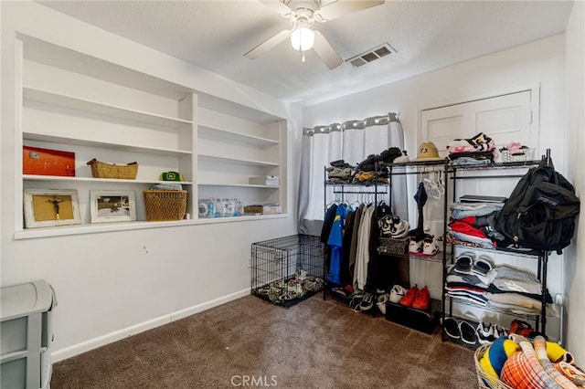 walk in closet featuring dark colored carpet and ceiling fan