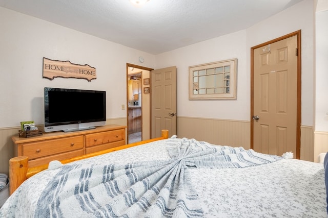 bedroom featuring a textured ceiling and wooden walls