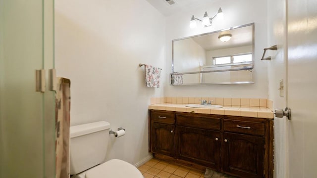 bathroom with tile patterned flooring, vanity, and toilet