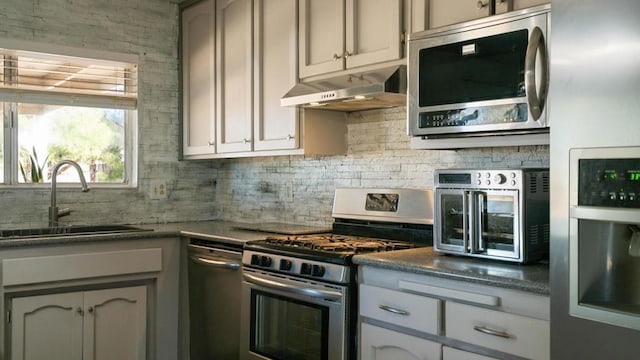 kitchen with appliances with stainless steel finishes, backsplash, and sink