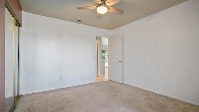 carpeted spare room featuring ceiling fan