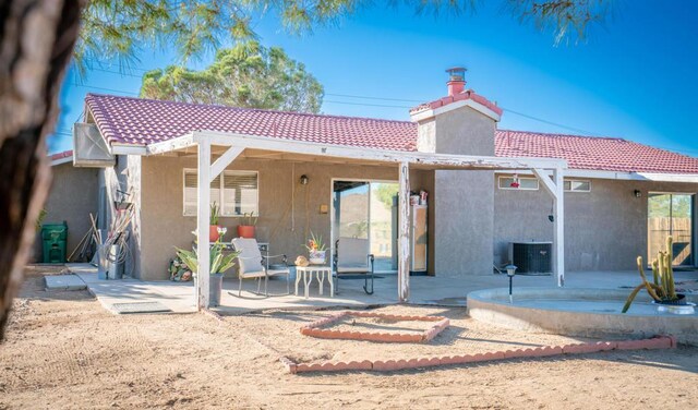 rear view of house featuring cooling unit and a patio